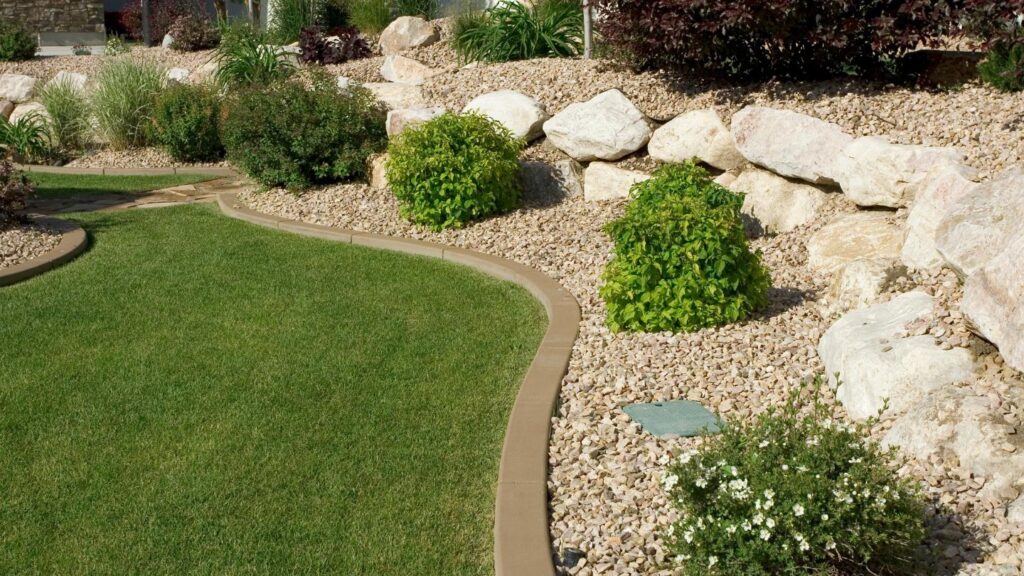 Curved lawn bordered by rocks and shrubs